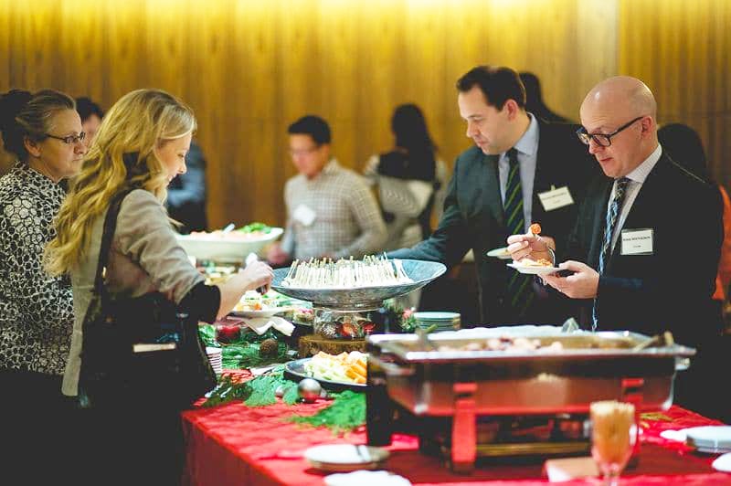 Office Christmas party - a group of colleagues by a buffet table